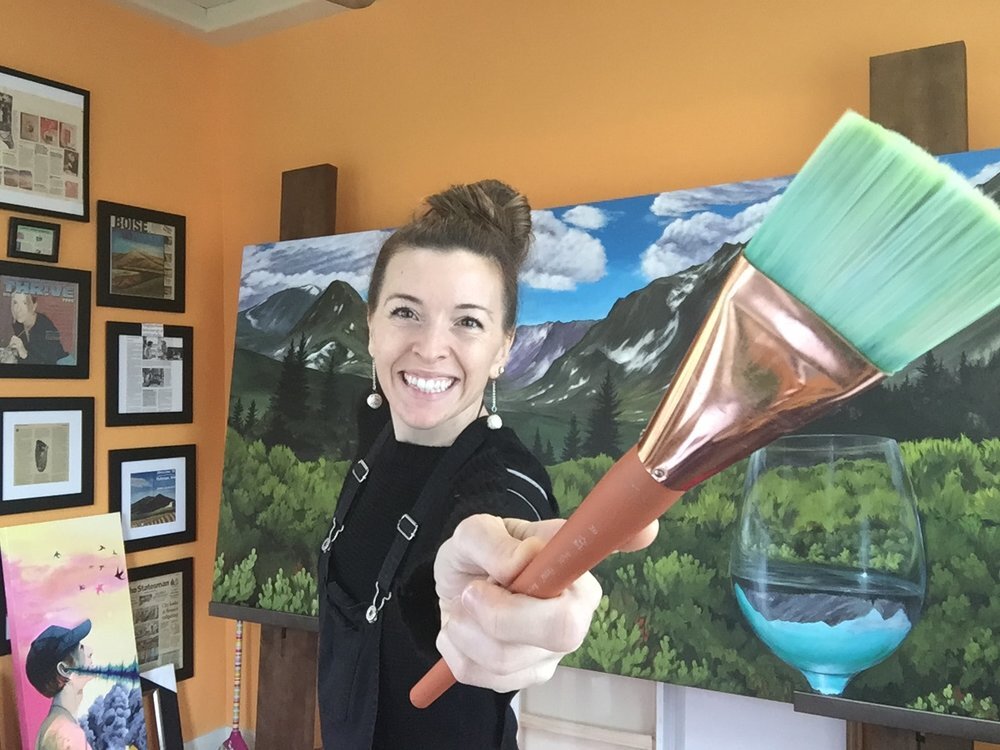 Artist Suzanne DeSoleil with her paintbrush and canvas in her studio.