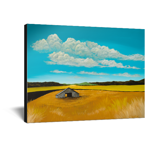 Archival print on canvas of a contemporary rural landscape painting of a rustic barn sitting in a yellow field with green hills in the distance under a blue sky filled with white fluffy clouds. 