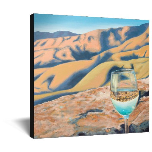 Archival print on canvas of a glass of white wine refracting sunlit foothills under a bright blue sky. 